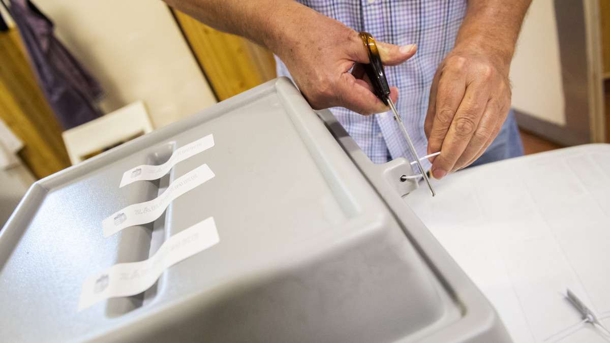 Számlálóbiztos levágja a plombát a szavazóurnáról a szavazóhelyiség bezárása után, mielőtt megkezdik a szavazatok számlálását a budapesti Narancs Óvodában kialakított szavazókörben az EP-választás napján, 2019. május 26-án.