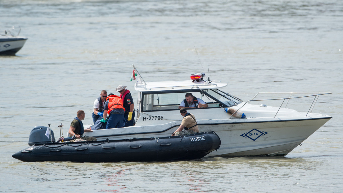 A hajóroncsból felhozott holttestet rendőrségi motorcsónakkal készülnek elvinni a balesetben elsüllyedt Hableány turistahajó közelében, a Margit hídnál 2019. június 4-én. A Hableány és a Viking Sigyn szállodahajó május 29-én késő este ütközött össze a Margit híd közelében, a turistahajó felborult és elsüllyedt, fedélzetén 33 dél-koreai állampolgárral - turistákkal és két idegenvezetővel -, valamint kéttagú magyar személyzettel. Hét embert a környező hajókon utazók kimentettek, hét dél-koreai állampolgár holttestét pedig még aznap megtalálták. Június 4-éig tíz holttest került elő.