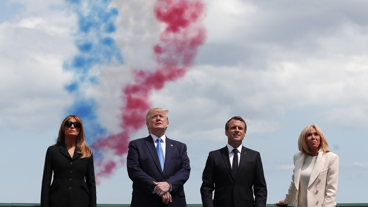 Donald Trump amerikai elnök (b2) és felesége, Melania Trump, Emmanuel Macron francia elnök (j2) és neje, Brigitte Macron (j) társaságában légibemutatót néz a normandiai partraszállás hetvenötödik évfordulója alkalmából tartott megemlékezésen a nyugat-franciaországi Colleville-sur-Mer amerikai katonai temetőjében 2019. június 6-án.