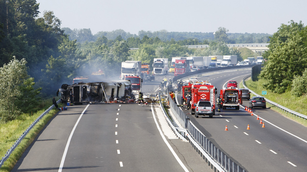 Tűzoltók dolgoznak egy kigyulladt, gyümölcsöt szállító kamion oltásán Szegerdőnél, az M7-es autópálya Budapest felé vezető oldalán 2019. június 17-én. A baleset miatt mindkét irányban lezárták az autópályát.