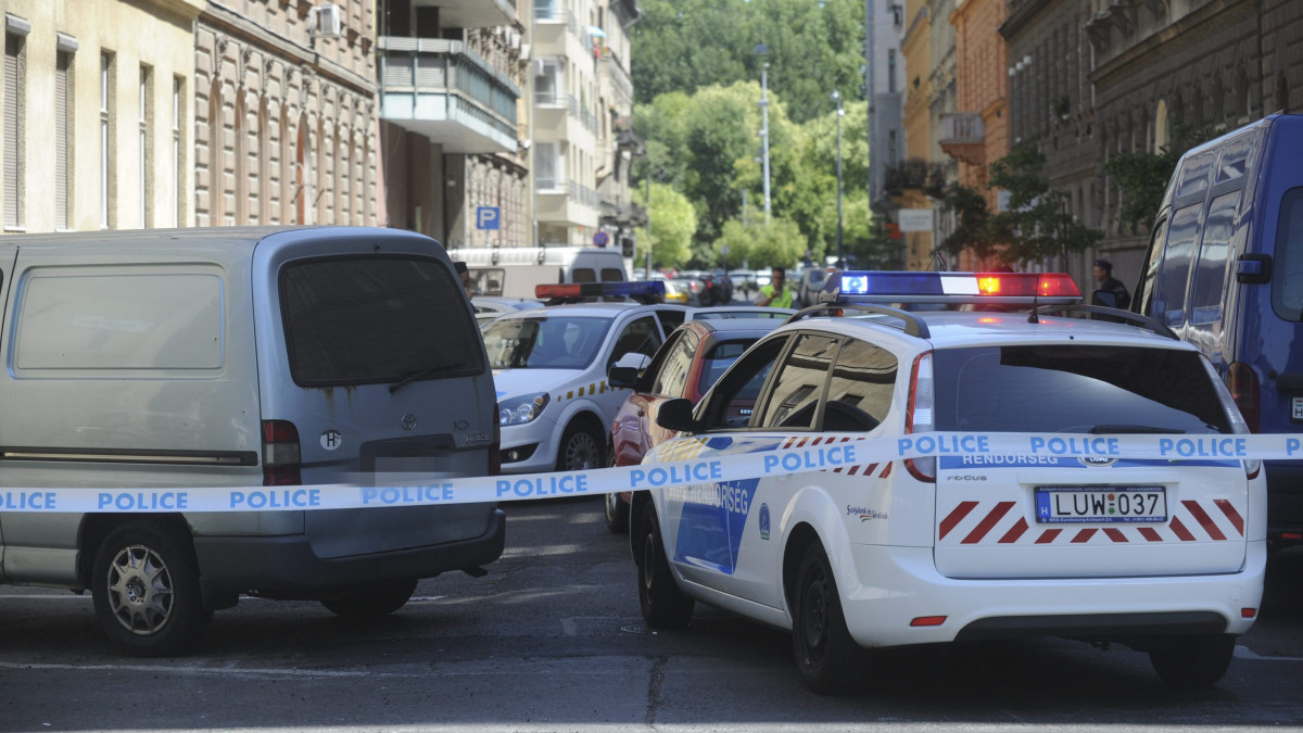 Rendőrautók vesznek közre egy kilőtt kerekű autót az erzsébetvárosi Peterdy és Murányi utca kereszteződésében, ahol meg nem erősített értesülés szerint egy kábítószeres ügyben intézkedtek a rendőrök 2013. július 22-én.