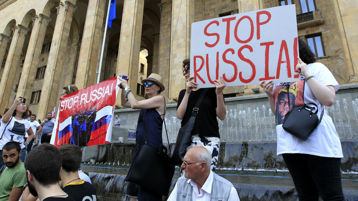 Ellenzéki tüntetők a kormány lemondását követelik a georgiai parlament tbiliszi épülete előtt 2019. június 20-án. A tüntetők megpróbálták megostromolni az épületet. A felirat jelentése: állítsátok meg Oroszországot!