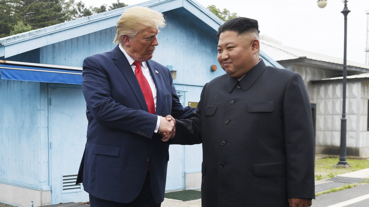Donald Trump amerikai elnök (b) és Kim Dzsong Un elsőszámú észak-koreai vezető a két Koreát elválasztó panmindzsoni demilitarizált övezetben húzódó demarkációs vonal déli oldalán 2019. június 30-án.