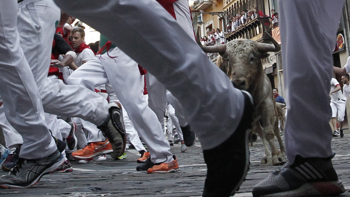 Pamplona, 2018. július 11.Bikák elől menekülő férfiak a pamplonai San Fermín fesztivál ötödik napján, 2018. július 11-én. A spanyol város védőszentjének tiszteletére 1591 óta évente megrendezett kilencnapos fiesta egyik fő attrakciója a reggelenkénti bikafuttatás, amelynek során férfiak százai teszik próbára bátorságukat azzal, hogy az arénába hajtott állatok előtt végigszaladnak Pamplona utcáin. (MTI/EPA/Jesus Diges)