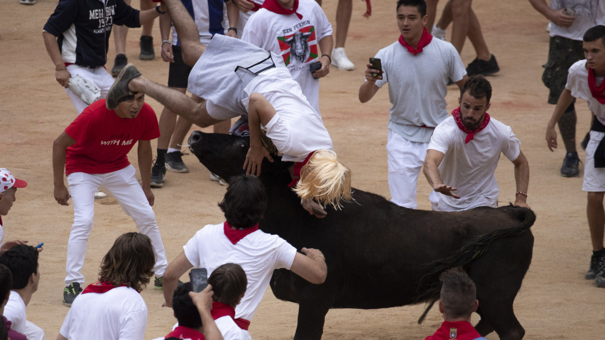 Felökleli az egyik futót egy fiatal bika a San Fermín fesztiválon Pamplonában 2019. július 14-én. A spanyol város védőszentjének tiszteletére 1591 óta évente megrendezett kilencnapos fiesta egyik fő attrakciója a reggelenkénti bikafuttatás, amelynek során férfiak százai teszik próbára bátorságukat azzal, hogy az arénába hajtott állatok előtt végigszaladnak Pamplona utcáin.