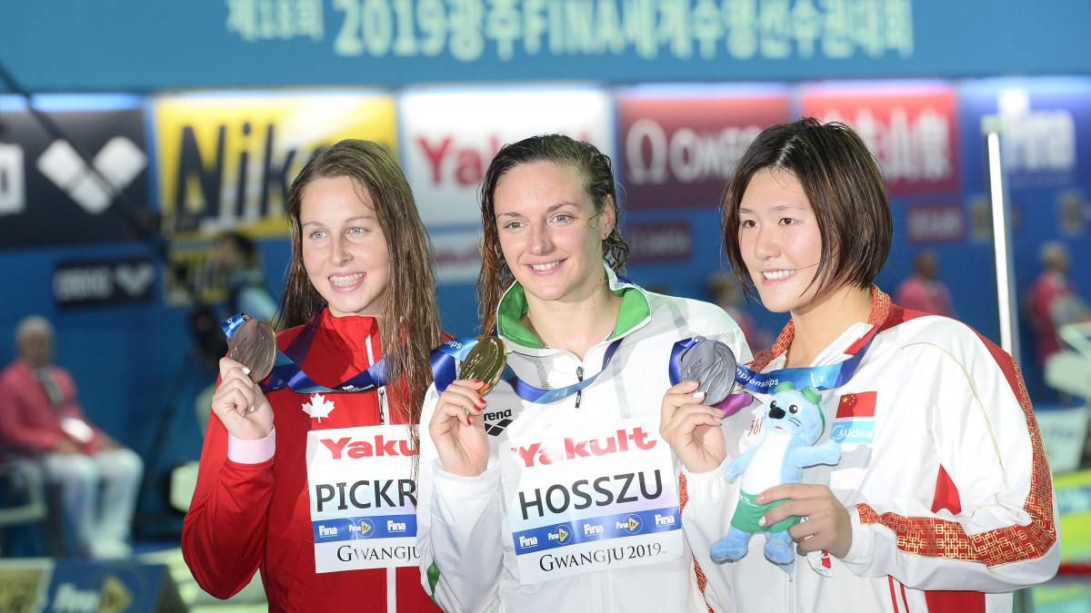 A győztes Hosszú Katinka (k), mellette az ezüstérmes kínai Je Si-ven (j) és a harmadik helyezett Sidney Pickrem a 200 méteres vegyesúszás eredményhirdetésén a 18. vizes világbajnokságon a dél-koreai Kvangdzsuban 2019. július 22-én.