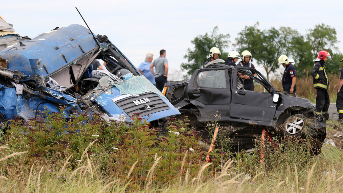 Tűzoltók Törökszentmiklós közelében, ahol egy ember meghalt, amikor egy kukoricaszállító teherautó összeütközött két személygépkocsival a 4-es főúton 2019. augusztus 8-án.
