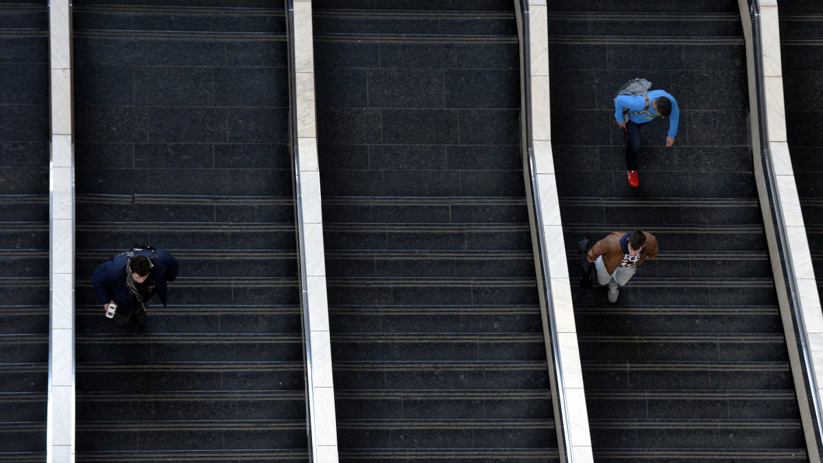 Lépcsőn közlekedő emberek a Keleti pályaudvar csarnokában 2015. március 24-én.