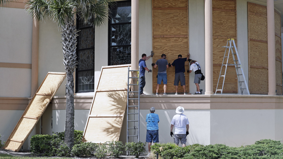 Munkások bedeszkázzák a Santa Maria del Mar katolikus templom ablakait a floridai Flagler Beach településen 2019. augusztus 30-án. Ron DeSantis floridai kormányzó Florida egészére rendkívüli állapotot hirdetett ki a közelgő Dorian hurrikán miatt. Az előrejelzések szerint a Dorian négyes erősségű hurrikánként érhet partot 210-230 kilométeres óránkénti sebességgel szeptember első napjaiban Floridában.