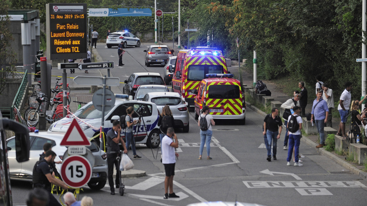 Hatósági járművek és a sajtó munkatársai a Laurent-Bonnevay metróállomás lezárt környékén, a kelet-franciaországi Lyon Villeurbanne nevű elővárosában, ahol egy férfi agyonszúrt egy 19 éves férfit, és kilenc embert megsebesített 2019. augusztus 31-én. A gyanúsítottat őrizetbe vették és előzetes letartóztatásba helyezték.