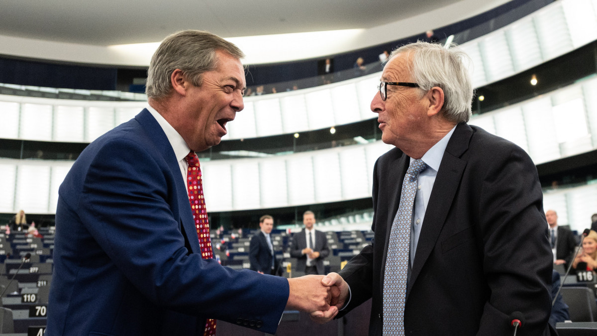 Nigel Farage, az általa alapított Brexit Párt vezetője (b) és Jean-Claude Juncker, az Európai Bizottság elnöke kezet fog az Európai Parlament (EP) Brexit-ügyi vitájának kezdete előtt Strasbourgban 2019. szeptember 18-án.