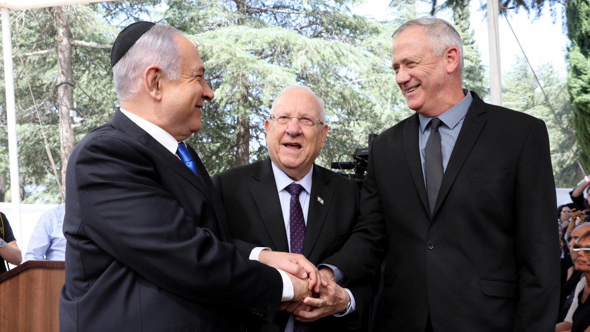 Benjámin Netanjahu izraeli miniszterelnök, a jobboldali Likud párt vezetője,  Reuven Rivlin államfő és Beni Ganz, az ellenzéki centrista Kék-fehér párt vezetője (b-j) részt vesz a Simón Peresz Nobel-békedíjas néhai izraeli államfő és miniszterelnök emléke előtt tisztelgő rendezvényen Jeruzsálemben 2019. szeptember 19-én. Netanjahu széles egységkormány megalakítására tett javaslatot Ganznak, miután a szeptember 17-i választásokon sem a jobb-, sem a baloldal nem szerzett többséget, és nem tud egyedül kormányt alakítani.