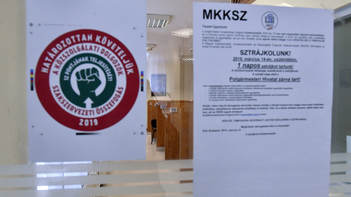 Feliratok a Magyar Köztisztviselők, Közalkalmazottak és Közszolgálati Dolgozók Szakszervezete (MKKSZ) egynapos sztrájkja alatt a XV. kerületi polgármesteri hivatal ajtaján 2019. március 14-én.