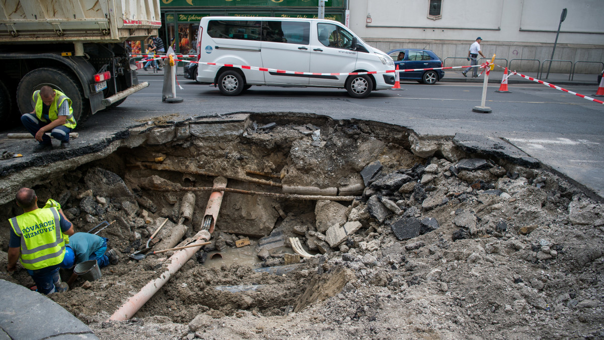 A beszakadt úttest kijavításán dolgoznak a fővárosi Ferenciek terénél 2019. szeptember 27-én. Közel két méter mély, két sáv szélességű gödör keletkezett a Kossuth Lajos utcában.