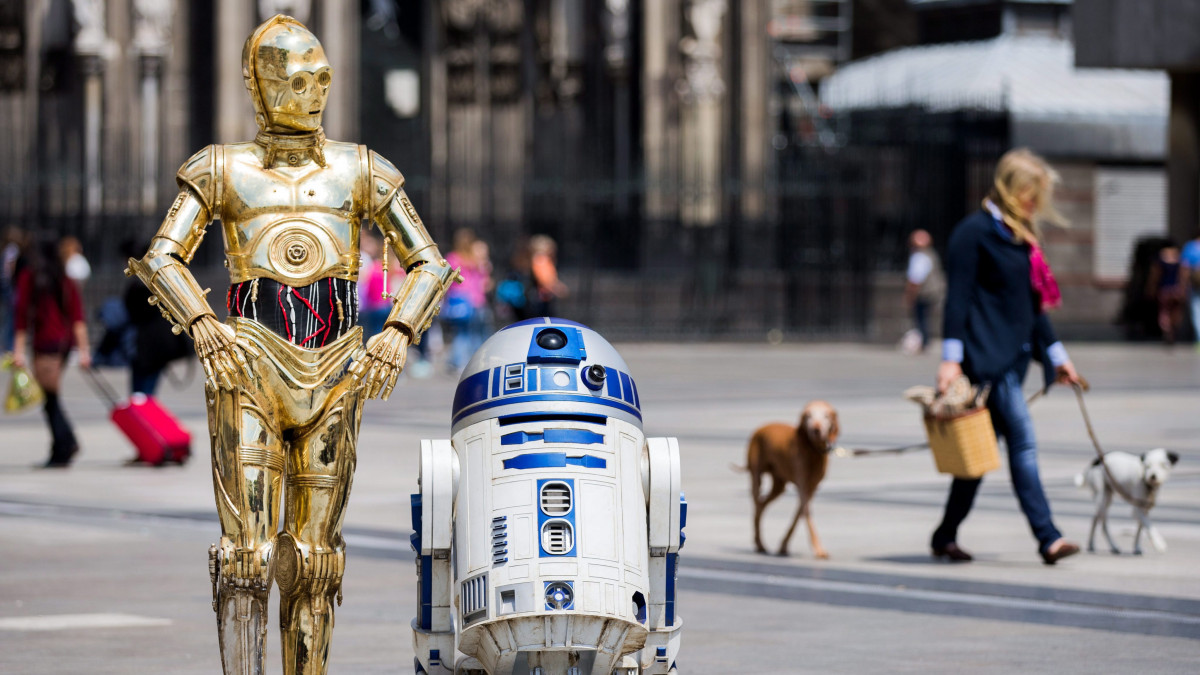 Köln, 2015. június 25.A Csillagok háborúja című mozifilmsorozat C-3PO és R2-D2 nevű szereplőinek viaszfigurái a kölni dóm előtt 2015. június 25-én. A Madame Tussauds Berlin panoptikum időszaki kiállítást nyitott Csillagok háborúja címmel, és a németországi nagyvárosokban indított reklámhadjáratba illeszkedik a viaszból készített C-3PO-figura. (MTI/EPA/Rolf Vennenbernd)