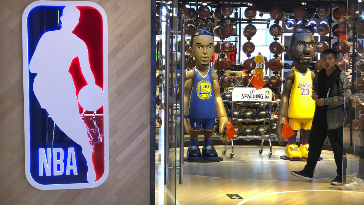 Stephen Curryt, a Golden State Warriors (b), valamint LeBron James-t, a Los Angeles Lakers játékosát ábrázoló figurák kínai zászlókkal a kezükben egy pekingi kosárlabdaüzletben 2019. október 8-án. A Kínai Központi Televízió (CCTV) ezen a napon bejelentette, hogy felfüggeszti az észak-amerikai profi kosárlabda-bajnokság (NBA) előszezonjának közvetítését az országban. Az ügy hátterében az áll, hogy Daryl Morey, a Houston Rockets általános igazgatója négy nappal korábban megosztott egy képet a Twitteren (azóta már törölte), amiben a kínai kormány ellen tüntető hongkongi tömeg melletti kiállásra szólított fel.
