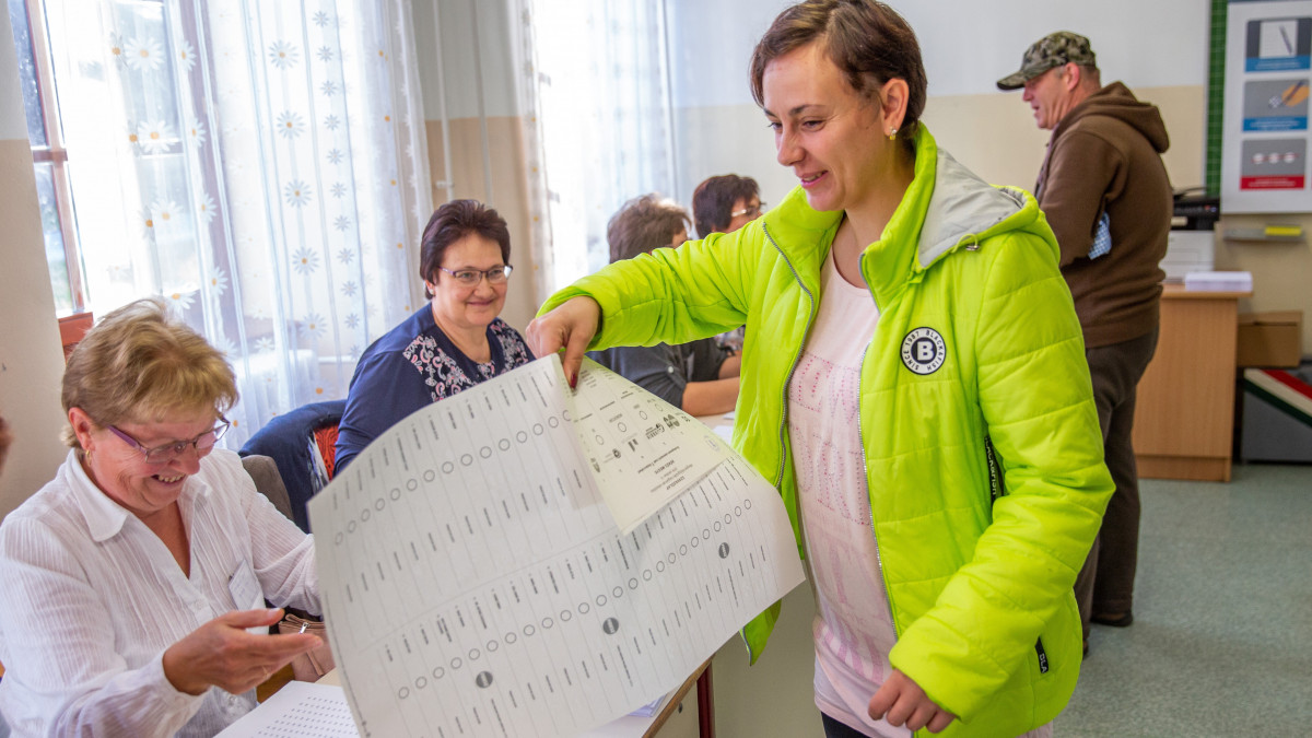 Zengő Zoltánné átveszi a szavazólapot a kunágotai általános iskolában kialakított szavazókörben 2019. október 13-án. A településen - ahol 49 egyéni listás jelölt indul - szavaznak az ország legnagyobb, 420x635 milliméteres szavazólapjával.