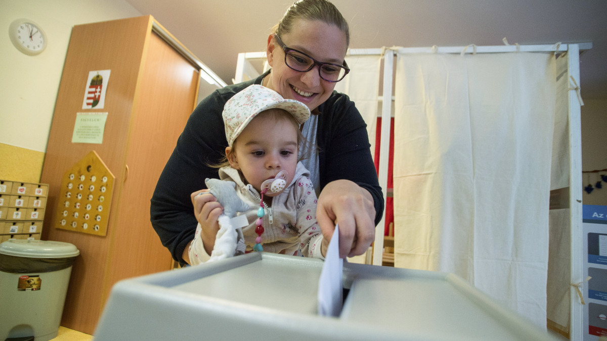 Szavazó nő gyermekével az önkormányzati választáson a XIII. kerületi Madarász Viktor óvodában kialakított szavazókörben 2019. október 13-án.