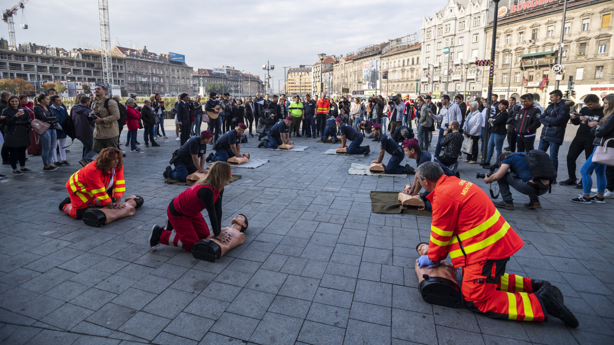 Rendőrök, valamint az Országos Mentőszolgálat, a Magyar Vöröskereszt és a Szív City munkatársai újraélesztési bemutatót tartanak a járókelőknek az újraélesztés világnapja alkalmából rendezett flashmobon a Keleti pályaudvar előtt 2019. október 16-án.