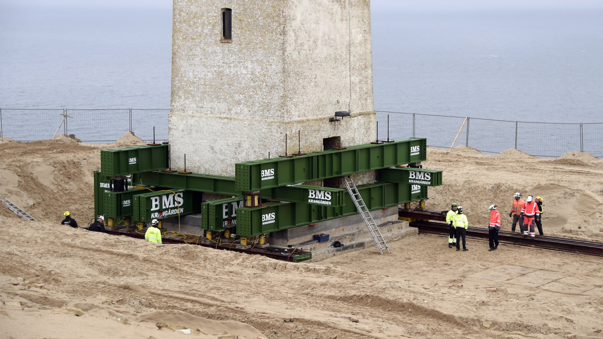 A Rubjerg Knude világítótornyot elindítani készülnek, hogy síneken 80 méterrel távolabb szállítsák az Északi-tenger partjától a dániai Jylland-félszigeten 2019. október 22-én. A csaknem 120 éves épület létét az eredeti helyén a parti erózió fenyegette, az előrejelzés szerint 2020-ra beledőlt volna a tengerbe.