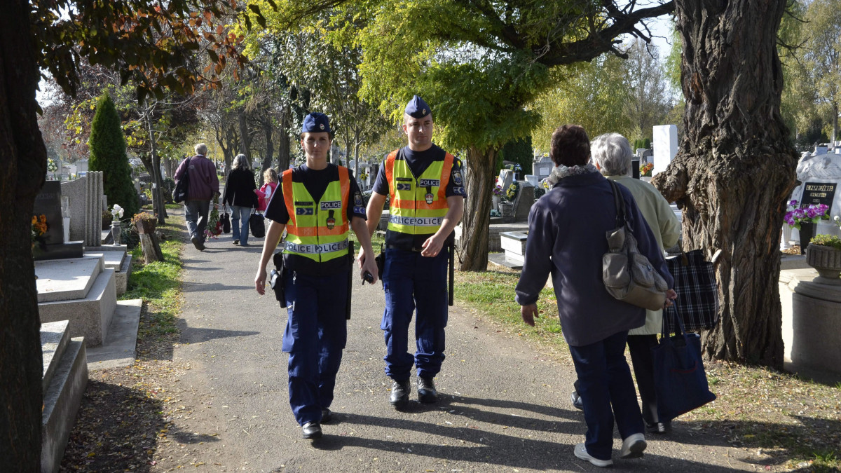 Tátrai Renáta rendőr törzsőrmester (b) és Szendi Ádám őrmester járőröznek a szolnoki temetőben 2013. október 30-án. A közelgő mindenszentek és halottak napja idején a rendőrség a polgárőrséggel közösen országszerte segíti a temetőkbe látogatók közlekedését.