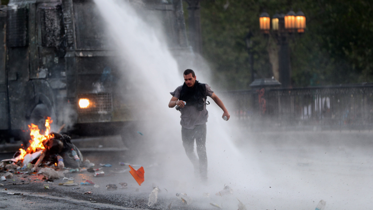 Rendőrségi vízágyú elől menekül egy demonstráló Santiagóban 2019. október 26-án,  amikor körülbelül egymillió ember tüntetett radikális reformokat követelve a chilei fővárosban.