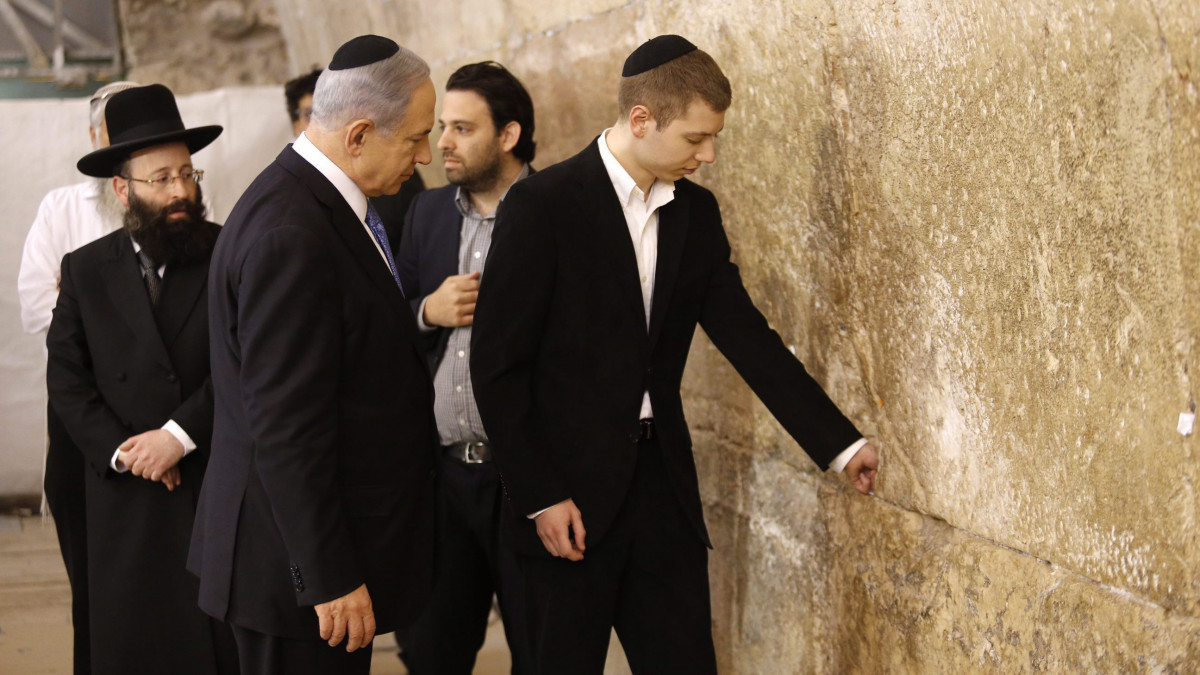 Tel-Aviv, 2015. március 18.Benjámin Netanjahu izraeli miniszterelnök, a jobbközép Likud párt vezetője (k) a fia, Jair (j) társaságában a jeruzsálemi siratófalnál 2015. március 18-án, miután az előző nap a Likud győzött az izraeli parlamenti választásokon. (MTI/EPA/Abir Szultan)