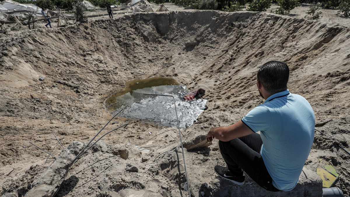 Izraeli rakéta becsapódása nyomán keletkezett, vízzel teli krátert néz egy férfi a Gázai övezet déli részén fekvő Hán Juniszban 2019. november 2-án, miután hajnalban Izrael több tucatnyi légicsapással megtorolta a Gázai övezetből indított, előző esti rakétatámadásokat. A légicsapásokban egy 27 éves palesztin gazdálkodó életét vesztette és ketten megsebesültek.