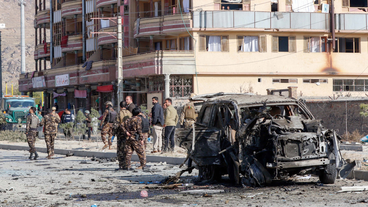 Az afgán biztonsági erők tagjai egy megsemmisült jármű mellett Kabulban 2019. november 13-án, miután egy öngyilkos merénylő robbanóanyaggal megrakott járművével nekihajtott egy páncélozott terepjárónak az út mentén a belügyminisztérium épületegyüttese közelében. A merényletben legkevesebb hét ember meghalt, hét másik megsebesült.
