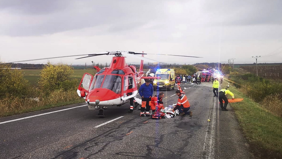 Mentőhelikopter és mentőautó mellett dolgoznak szakemberek egy közúti baleset helyszínén, a nyugat-szlovákiai Nyitragerencsér közelében, ahol egy kamionnal ütközött egy autóbusz, amely az árokba szaladt és felborult 2019. november 13-án. A szerencsétlenségben legkevesebb tizenketten meghaltak, a sebesültek száma megközelíti a húszat.