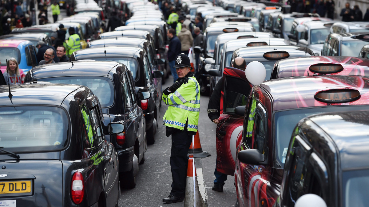 London, 2016. február 10.Hagyományos londoni taxik zárják le az utat a Whitehallon, ahol a taxisok az Uber közösségi személyszállító szolgáltatás működésének engedélyezése ellen tiltakoznak 2016. február 10-én. (MTI/EPA/Andy Rain)