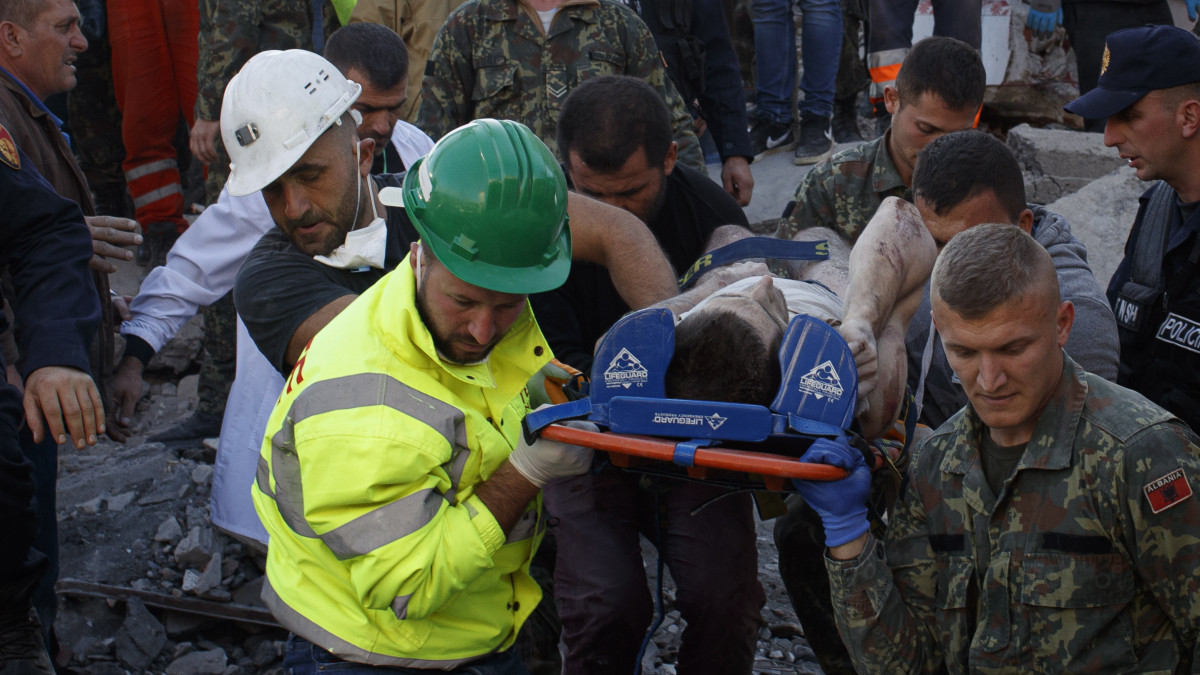 Romok alól kimentett sérültet visznek mentők Thumanéban 2019. november 26-án, miután 6,4-es erősségű földrengés volt Albánia nyugati részén. Legalább tizennégy ember életét vesztette, több mint hatszáz megsebesült.