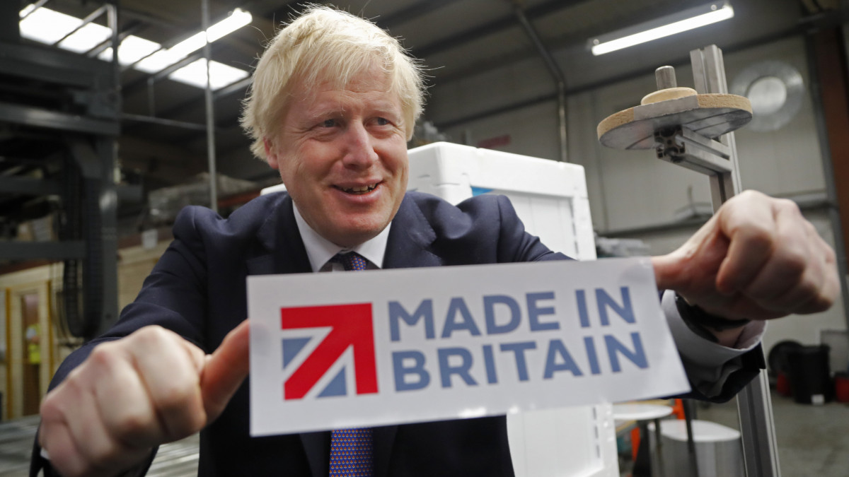 A választási kampánykörúton levő Boris Johnson konzervatív párti brit miniszterelnök matricát mutat a háztartási gépeket gyártó Ebac üzemében, az észak-angliai Newton Aycliffe-ben 2019. november 20-án. Nagy-Britanniában december 12-én tartanak előrehozott parlamenti választást.