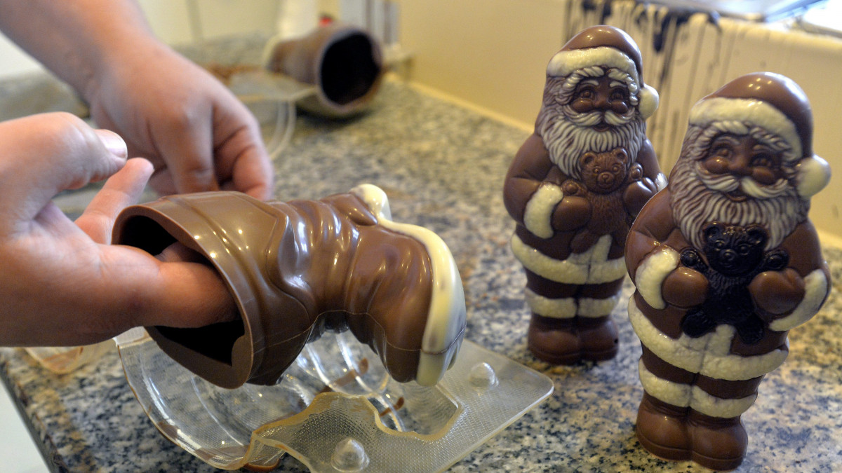 Többszínű csokoládámikulások a Pelle-Molnár Kézműves Bonbon Kft. oroszlányi műhelyében, az előtérben egy csokoládécsizmát vesznek ki az öntőformából 2013. október 28-án.