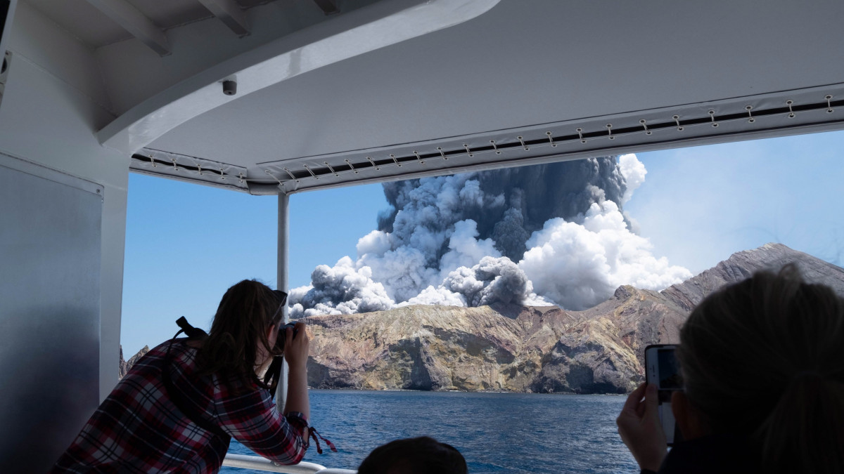 A Michael Schade által közreadott képen kirándulók hajóról fényképezik az új-zélandi Fehér-sziget váratlanul kitört tűzhányóját 2019. december 9-én. A Whakaariként is ismert lakatlan szigeten legkevesebb öten életüket vesztették, és sokan eltűntek.