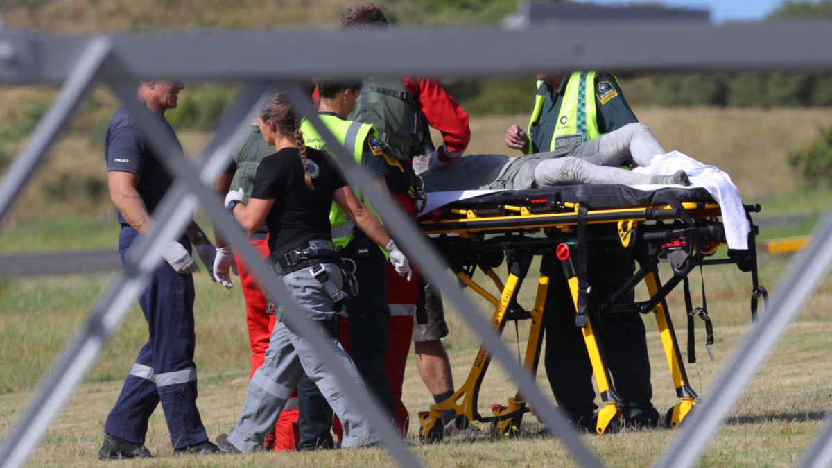 A fehér-szigeti vulkán kitörtésében megsérült emberek egyikét érkeztetik az új-zélandi Északi-sziget Whakatane leszállópályáján 2019. december 9-én. A turisták által látogatott, lakatlan szigeten több kiránduló eltűnt és megsérült. A szigetre hét mentőhelikopter indult orvosi személyzettel.