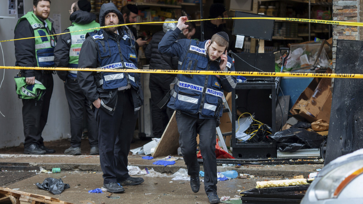Hivatalos személyek intézkednek a Jersey Cityben elkövetett lövöldözés egyik helyszínén, egy kóser vegyesboltnál 2019. december 11-én. Az előző esti lövöldözés a város temetőjében kezdődött egy igazoltatást követően, majd a két fegyveres férfi elbarikádozta magát a boltban. Az incidensben hatan meghaltak, köztük egy rendőr és a két elkövető, és többen megsebesültek.