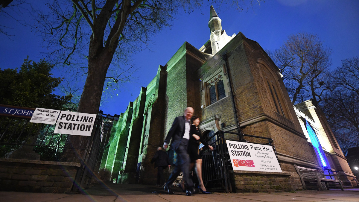 A londoni St. Johns templomban kialakított szavazóhelyiségből távozik egy pár 2019. december 12-én, az előrehozott parlamenti választástok napján.