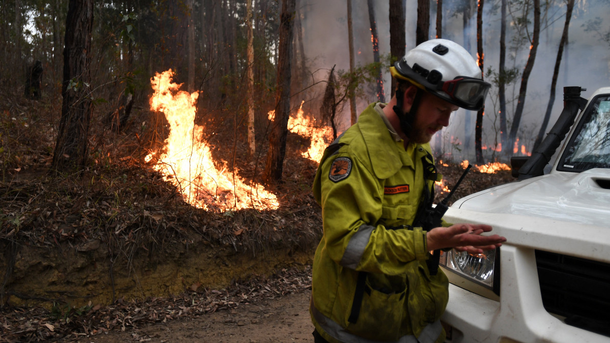 Tűzoltó az Új-Dél-Wales államban fekvő Ulladulla közelében pusztító bozóttűz helyszínén 2020. január 5-én. Az október óta tomboló bozót- és erdőtüzek miatt emberek tízezreit kell kimenteni Ausztrália délkeleti térségéből. Ausztrália-szerte 5,5 millió hektárnyi földterület égett le, 21 ember meghalt és több mint ezer ház vált a lángok martalékává.