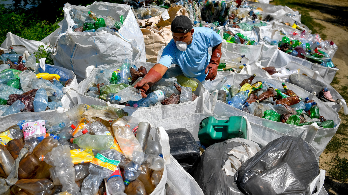 A tavaszi árhullámokat követően összetorlódott mintegy nyolcezer tonna kommunális és növényi eredetű hulladékot válogatja egy munkás a kiskörei vízlépcsőnél 2019. július 16-án. Vízügyi, civil és vállalati együttműködés segíti a Tisza hulladékmentesítését, az idén rekordméretű szennyezés felszámolása legalább négy hónapot vesz majd igénybe.