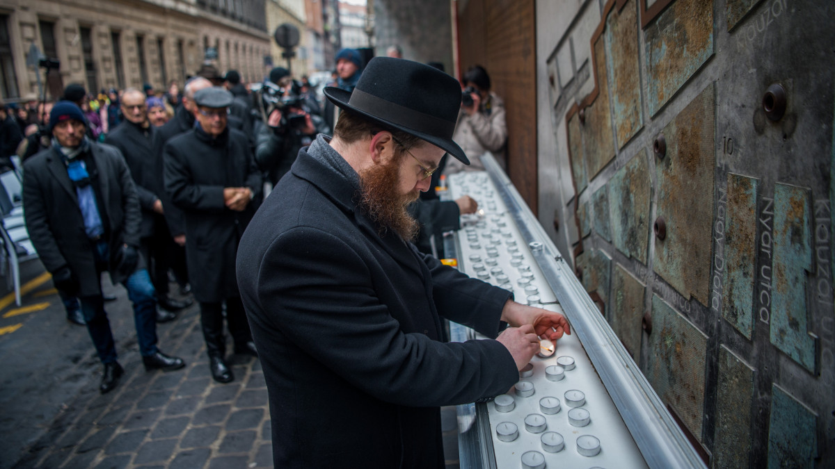 Köves Slomó, az Egységes Magyarországi Izraelita Hitközség (EMIH) vezető rabbija mécsest gyújt a budapesti gettó felszabadulásának 75. évfordulója alkalmából tartott megemlékezésen az egykori gettó emlékfalánál a VII. kerületi Dohány utcában 2020. január 17-én.