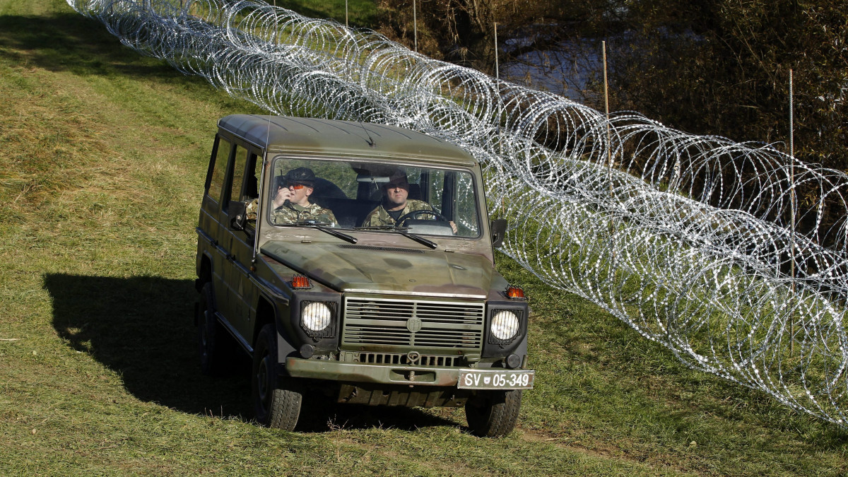 Veliki Obrez, 2015. november 11.Szlovén katonák pengésdrótból épített kerítés mellett a szlovén-horvát határon Veliki Obreznél 2015. november 11-én. A kerítést az illegális bevándorlók ellenőrizetlen belépésének megakadályozására szánják. (MTI/EPA/Antonio Bat)