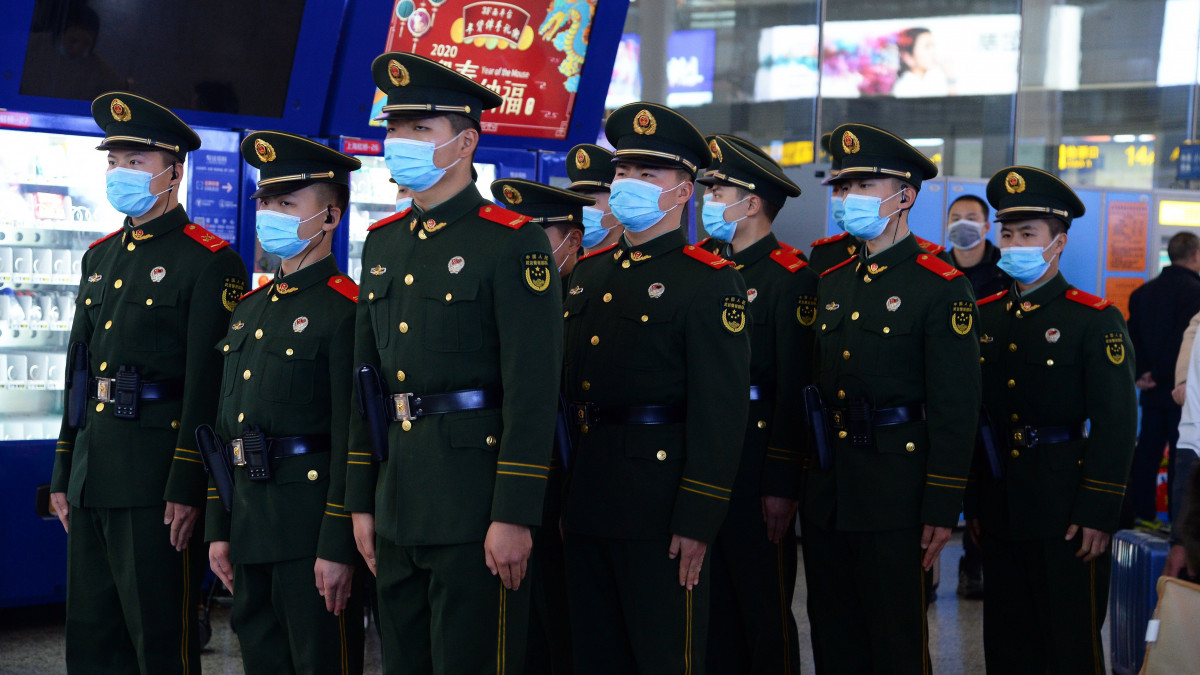 A tüdőgyulladást okozó új koronavírus miatt védőmaszkot viselnek a sanghaji Hung Csiao vasútállomáson járőröző katonák 2020. január 22-én. Kínában 17-re emelkedett a tüdőgyulladást okozó új koronavírusban elhunytak, valamint 470-re nőtt a fertőzöttek száma. A járvány kiindulópontjának számító közép-kínai Vuhanban óvintézkedések léptettek életbe: a repülőtéren és vasútállomásokon ellenőrzik az utasok testhőmérsékletét, és karanténba helyezik mindazokat, akiknél lázas tüneteket tapasztalnak. A kínai városokban a holdújévi munkaszünet miatt várhatóan jelentősen emelkedik az utasforgalom.