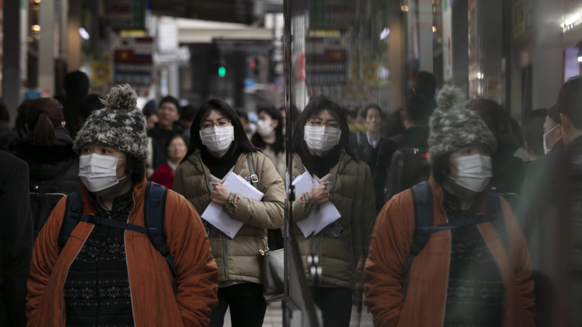 Védőmaszkot viselő gyalogosok Tokió Sindzsuku nevű városrészében 2020. január 27-én. Az új, tüdőgyulladást okozó koronavírus halálos áldozatainak a száma 80 fölé nőtt Kínában, és világszerte közel háromezer fertőzöttet regisztráltak. A kórokozó a 11 millió lakosú Hupej tartománybeli Vuhan egyik halpiacán bukkant fel először, ahol illegálisan árusították a vadhúst.