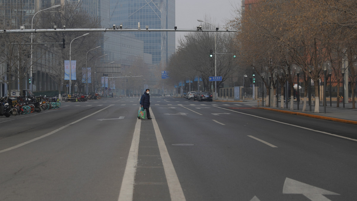 Védőálarcos járókelő egy néptelen pekingi utcán 2020. január 27-én. A kínai hatóságok három nappal meghosszabbították a holdújévi szünetet, hogy fékezzék a koronavírus okozta járvány terjedését, amely Hupej tartományból indult.