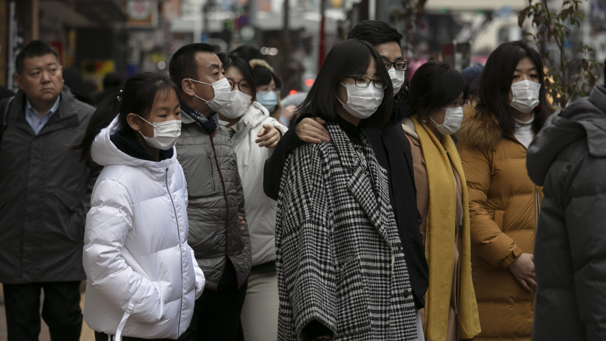 Védőmaszkot viselő gyalogosok Tokió Sindzsuku nevű városrészében 2020. január 27-én. Az új, tüdőgyulladást okozó koronavírus halálos áldozatainak a száma 80 fölé nőtt Kínában, és világszerte közel háromezer fertőzöttet regisztráltak. A kórokozó a 11 millió lakosú Hupej tartománybeli Vuhan egyik halpiacán bukkant fel először, ahol illegálisan árusították a vadhúst.