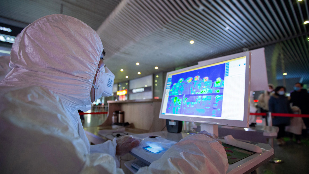 Az utasok testhőmérsékletét ellenőrzi infravörös hőkamerával egy védőfelszerelést viselő egészségügyi dolgozó a kelet-kínai Nancsing nagyváros déli vasúti pályaudvarán 2020. január 27-én. Az új, tüdőgyulladást okozó koronavírus halálos áldozatainak a száma 80 fölé nőtt Kínában, és világszerte közel háromezer fertőzöttet regisztráltak. A kórokozó a 11 millió lakosú Hupej tartománybeli Vuhan egyik halpiacán bukkant fel január elején.
