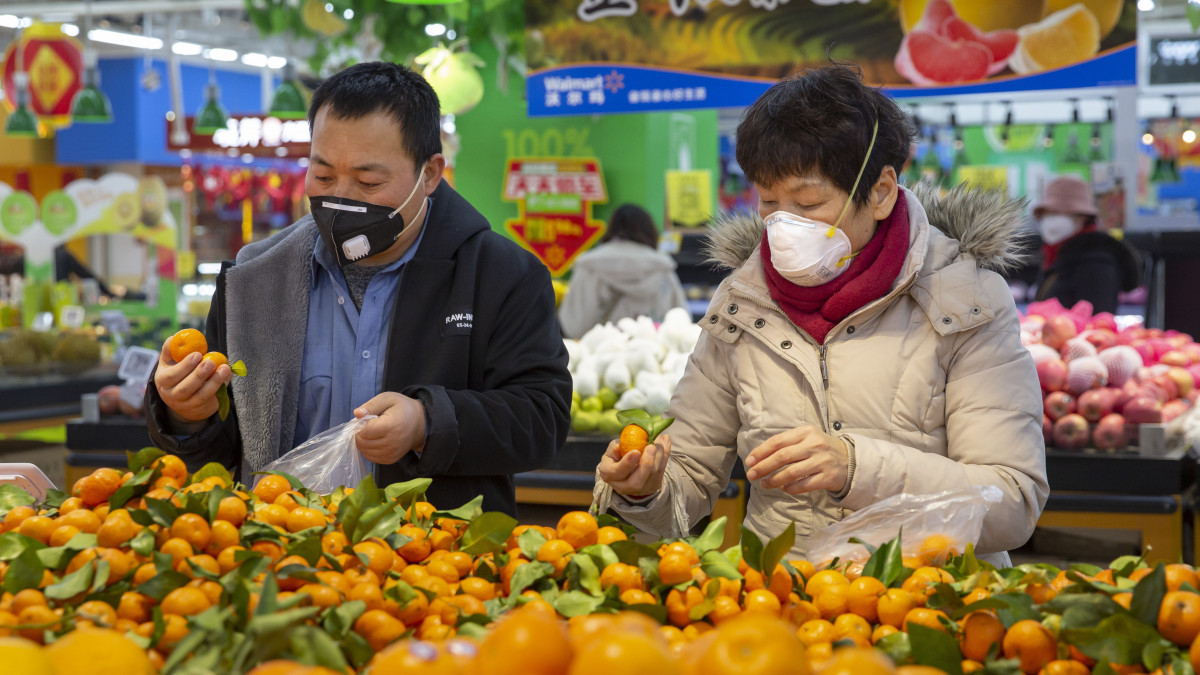 A koronavírus okozta járvány miatt védőmaszkot viselnek vásárlók egy pekingi ABC-áruházban 2020. január 28-án. A kínai Hupej tartományban kezdődő, és már a világ több országában megjelenő  járvány eddig legkevesebb 106 ember halálát okozta Kínában.