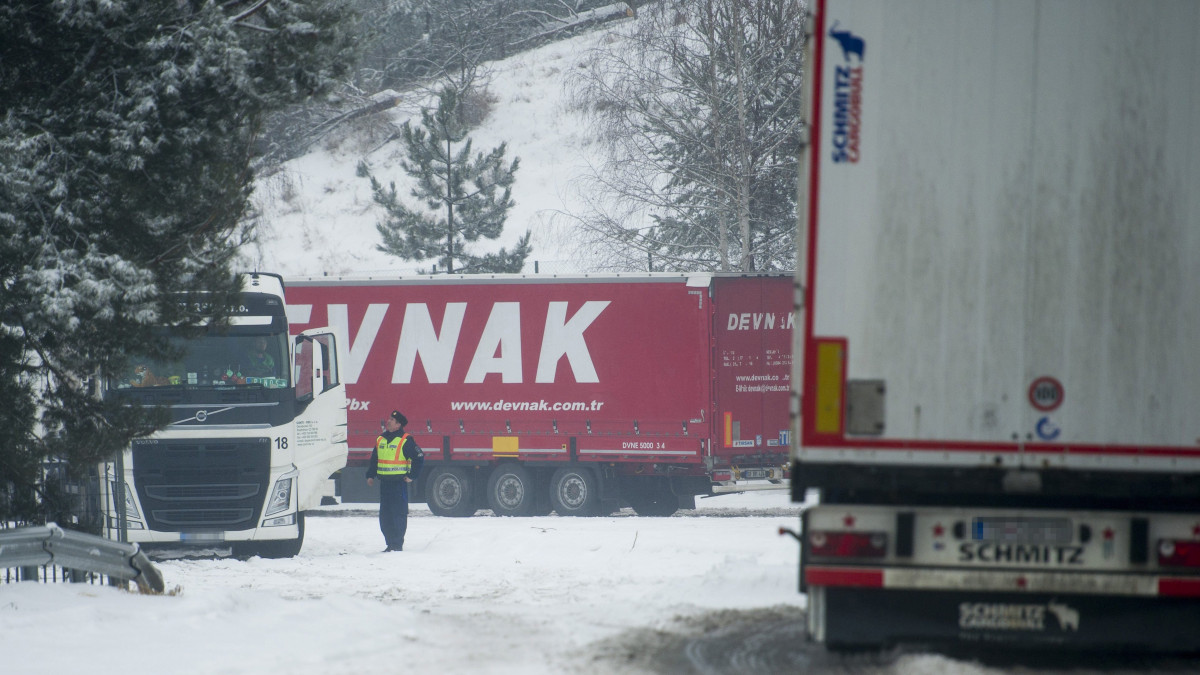 Egy rendőr egy kamionsofőrrel beszél a magyar-szlovák határnál, Somoskőújfaluban 2017. február 1-jén. A szlovák hatóságok baleset miatt lezárták a tehergépjármű-forgalom elől a 21-es utat a somoskőújfalui határátkelőhelyen ezen a napon.