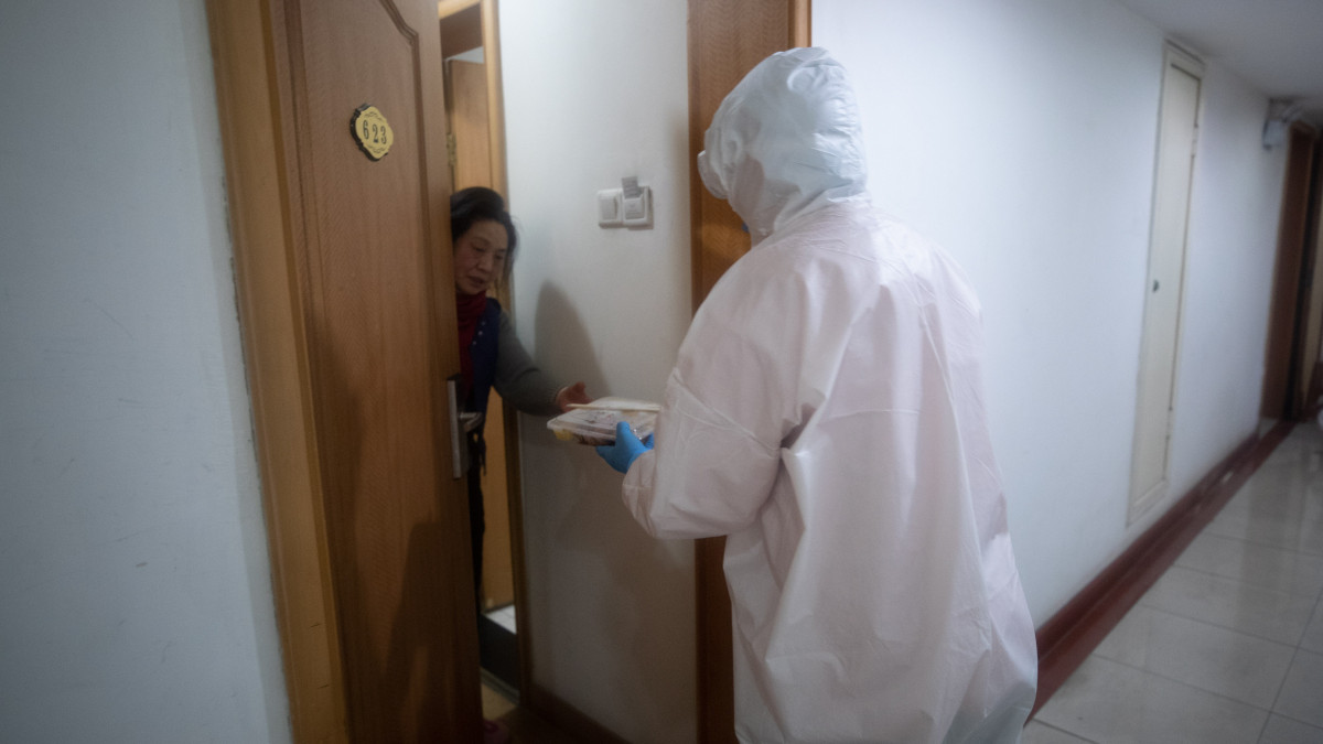 Védőruhás személyzet étel visz a pácienseknek egy karanténként működő vuhani szállodában 2020. február 5-én. Az először a kínai Hupej tartomány székvárosában, Vuhanban azonosított koronavírus előidézta járvány halálos áldozatainak száma világszerte 492, a halálesetek több mint 97 százaléka továbbra is Hupejre korlátozódik, és azon belül is 73 százalékot haladja meg a Vuhanban elhunytak száma.